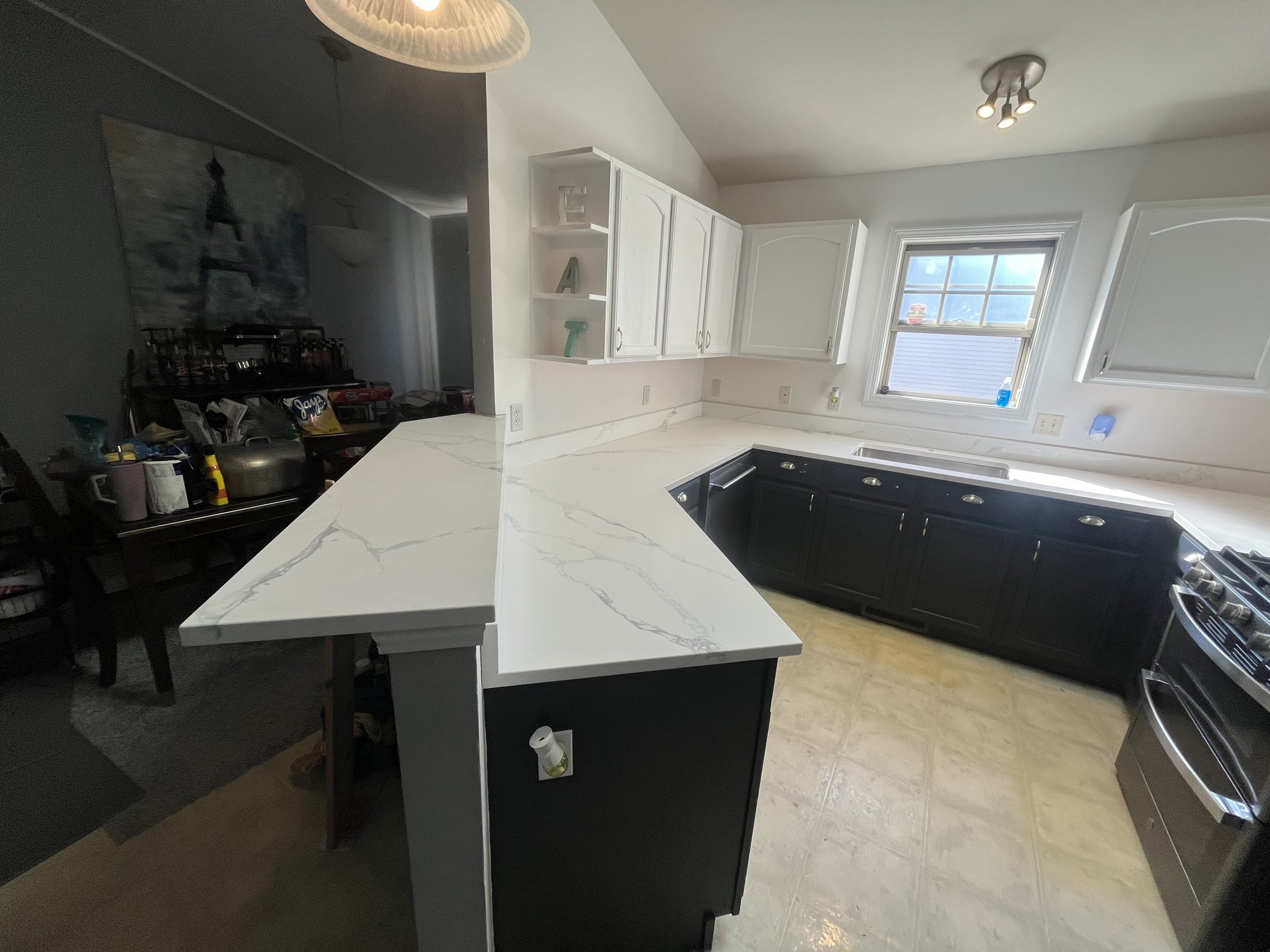 White kitchen countertops with dark cabinetry installed by STONELUX